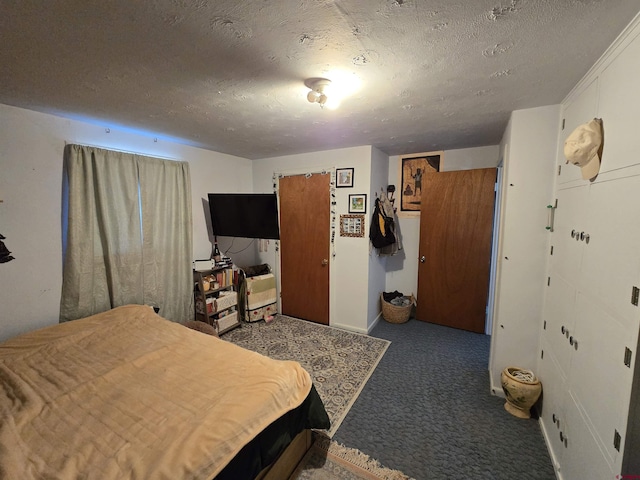 bedroom with dark colored carpet and a textured ceiling