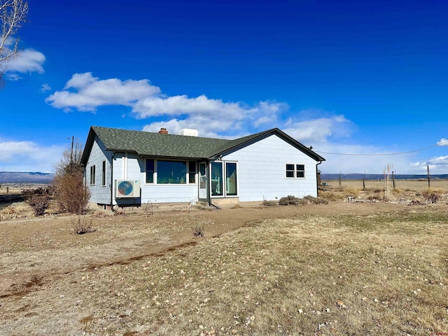 single story home featuring ac unit and a front lawn