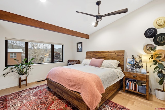 bedroom featuring ceiling fan, lofted ceiling with beams, and light wood-type flooring