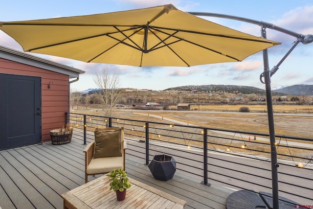 wooden terrace featuring a mountain view and a rural view