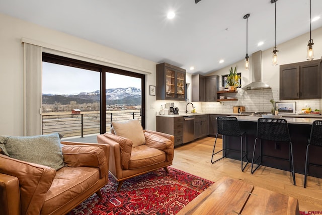 interior space featuring lofted ceiling, a mountain view, sink, and light wood-type flooring