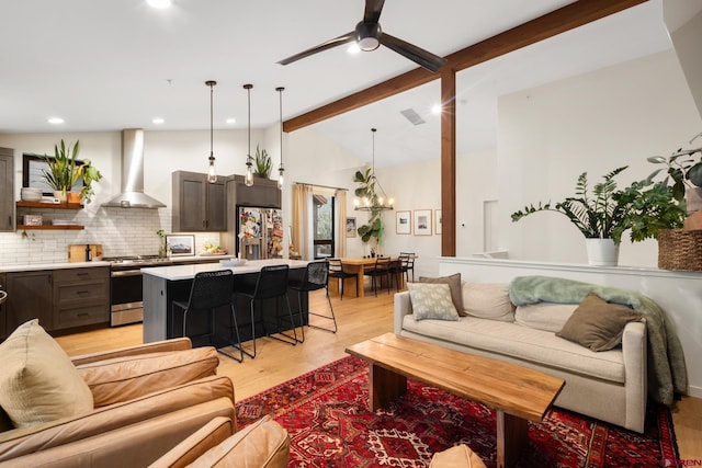 living room with beamed ceiling, high vaulted ceiling, ceiling fan with notable chandelier, and light hardwood / wood-style floors