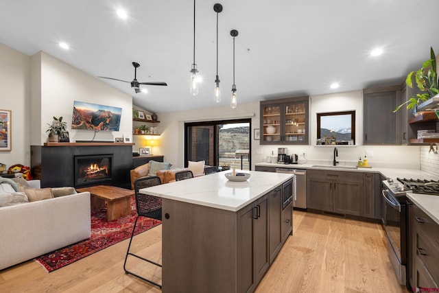 kitchen featuring sink, range with gas cooktop, a center island, stainless steel dishwasher, and pendant lighting
