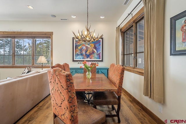 dining area featuring hardwood / wood-style floors and a chandelier