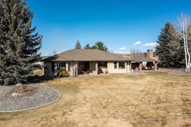 rear view of house featuring a lawn and a patio