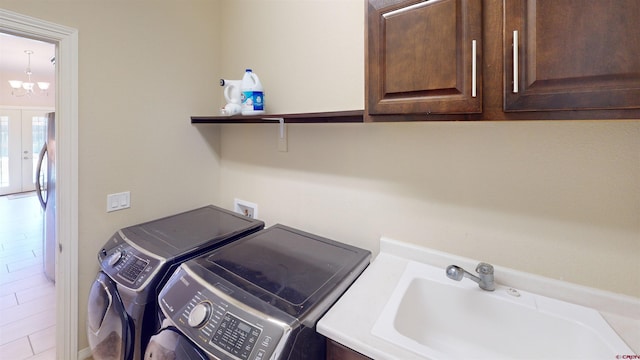 washroom featuring sink, cabinets, independent washer and dryer, french doors, and a chandelier