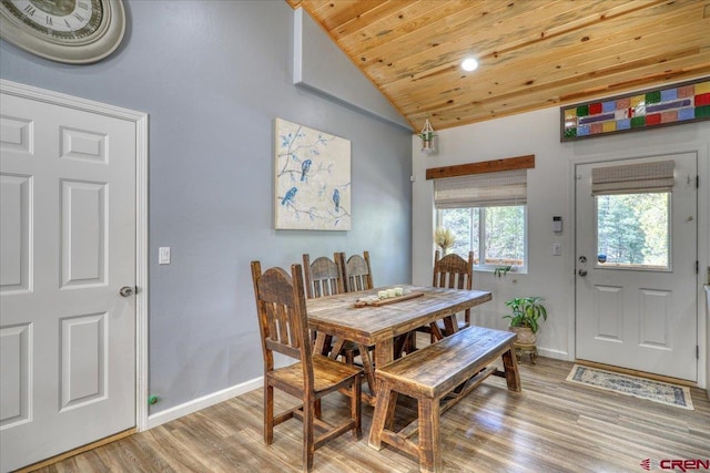 dining area featuring vaulted ceiling, light hardwood / wood-style flooring, and wooden ceiling