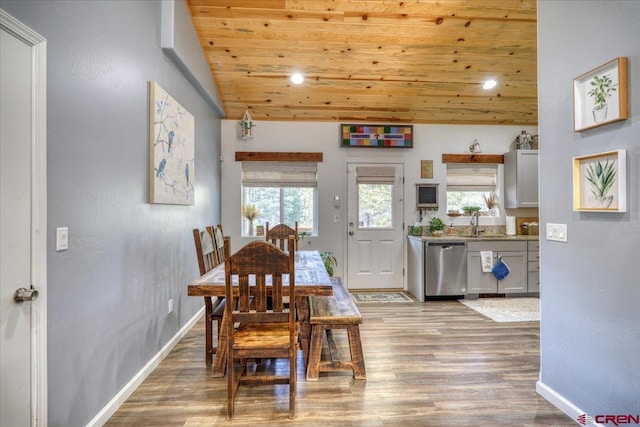 dining area featuring wood-type flooring, sink, vaulted ceiling, and wooden ceiling