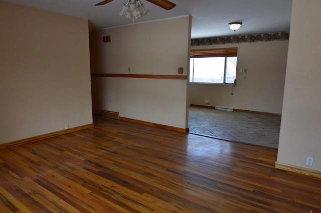 spare room with dark hardwood / wood-style flooring, ceiling fan, and baseboard heating