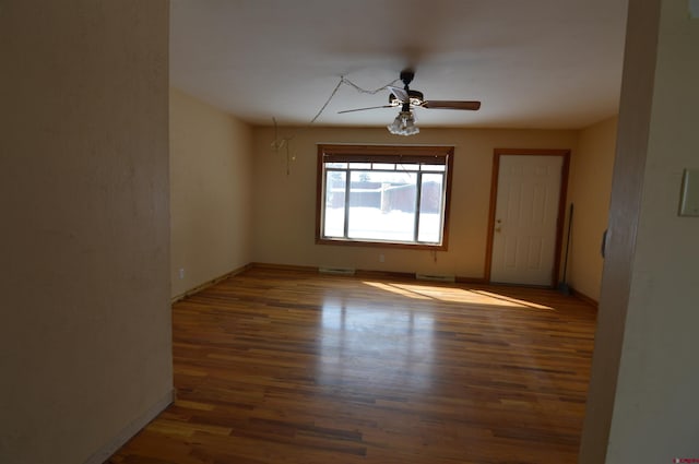 unfurnished room with ceiling fan and dark hardwood / wood-style flooring