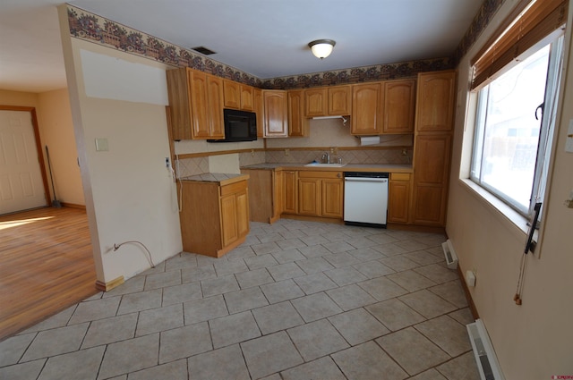 kitchen featuring tasteful backsplash, white dishwasher, sink, and light tile patterned floors