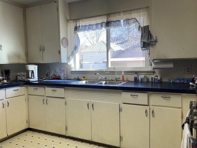 kitchen with stove, sink, and white cabinets