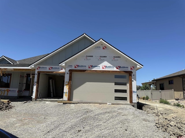 2319 Stone Bridge Dr, Montrose, CO 81401 - unfinished property featuring board and batten siding, a garage, and gravel driveway