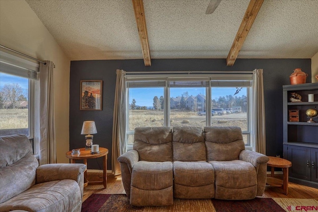 living room with wood-type flooring, vaulted ceiling with beams, and a textured ceiling