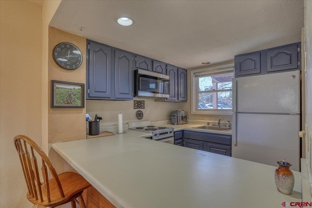 kitchen featuring blue cabinets, sink, white refrigerator, a textured ceiling, and electric stove