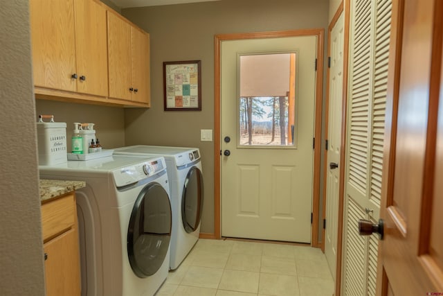 laundry room featuring washer and clothes dryer and cabinets