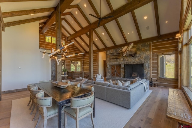 living room with high vaulted ceiling, a chandelier, light wood-type flooring, and a fireplace