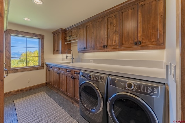 washroom featuring washing machine and dryer, cabinets, and sink