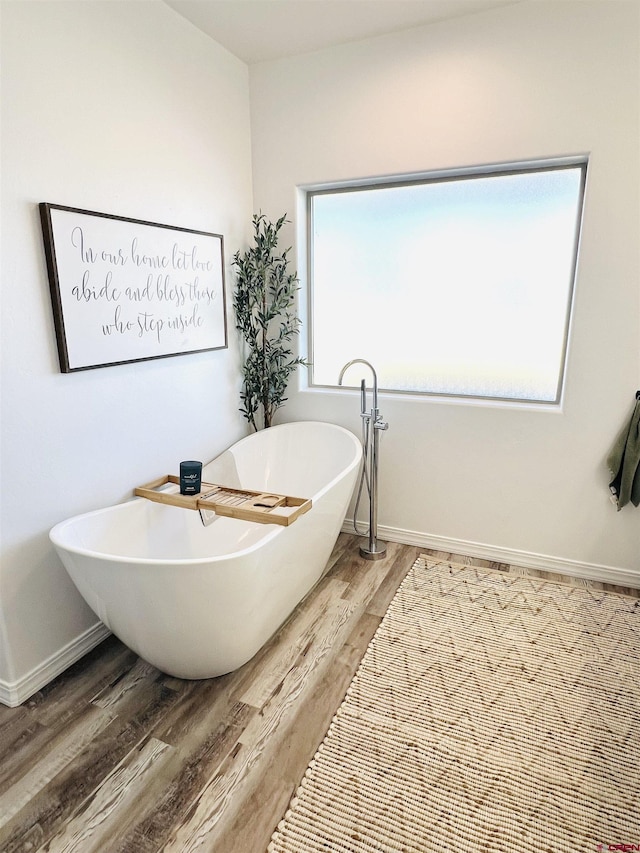 bathroom featuring hardwood / wood-style flooring and a washtub