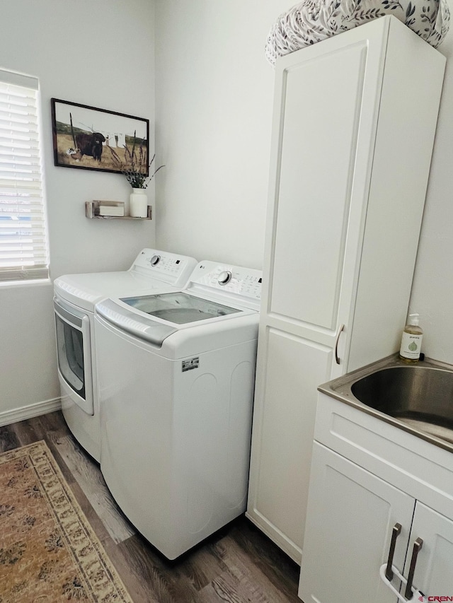 laundry room with dark hardwood / wood-style flooring, sink, separate washer and dryer, and cabinets