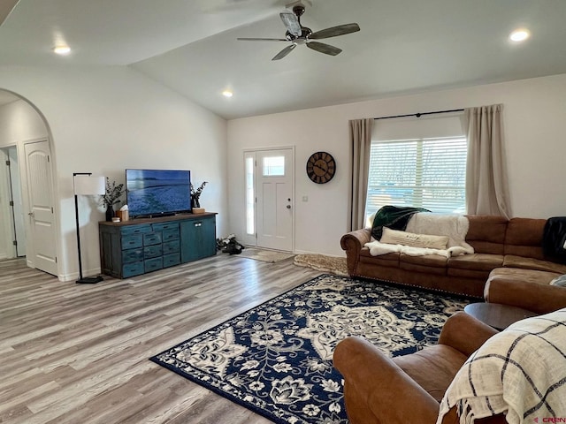 living room featuring light hardwood / wood-style floors, lofted ceiling, and ceiling fan