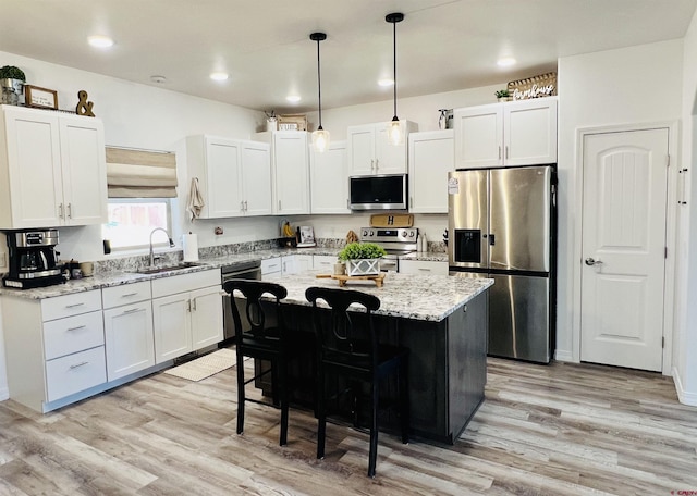 kitchen featuring sink, a kitchen island, white cabinets, and stainless steel appliances