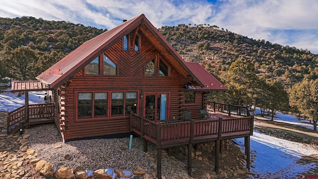 rear view of house featuring a wooden deck