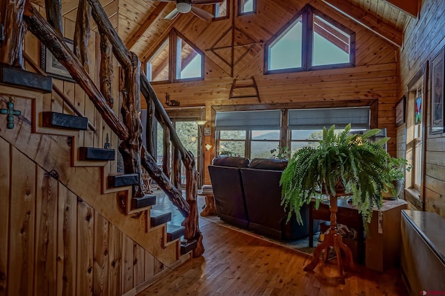 interior space featuring wood-type flooring, beamed ceiling, wood walls, and wooden ceiling