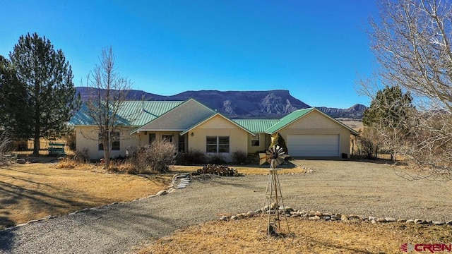 ranch-style home featuring a garage and a mountain view