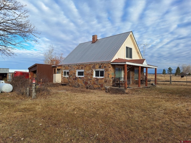 back of house featuring a yard and a porch