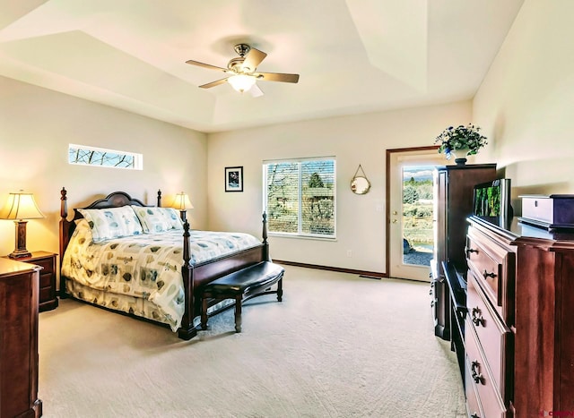 bedroom with access to outside, light colored carpet, ceiling fan, and a raised ceiling