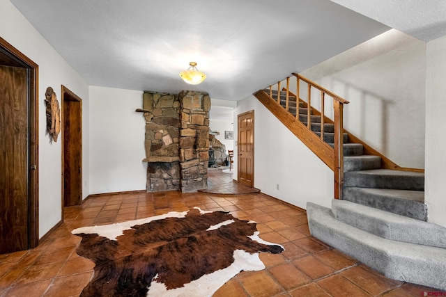 living area featuring stairs, baseboards, and tile patterned floors