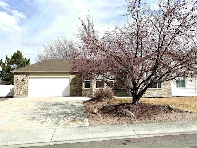 view of front of property with a garage, stone siding, and driveway