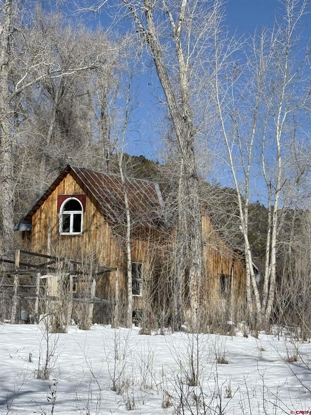 snow covered structure featuring a barn