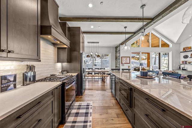 kitchen featuring pendant lighting, custom exhaust hood, decorative backsplash, appliances with stainless steel finishes, and light wood-style floors