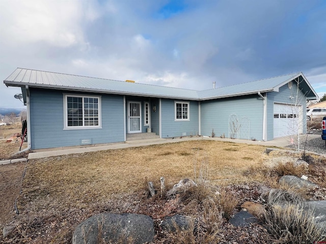 single story home with metal roof, a front lawn, and an attached garage