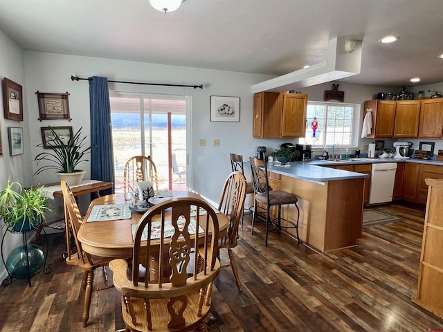 interior space with brown cabinetry, light countertops, a peninsula, and a breakfast bar area