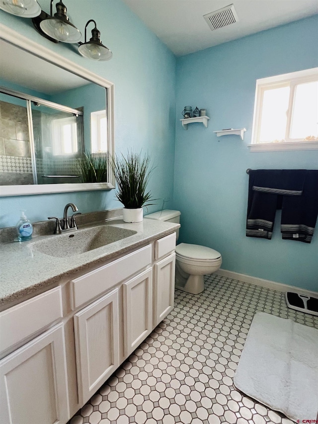 full bathroom featuring visible vents, toilet, a shower stall, vanity, and baseboards