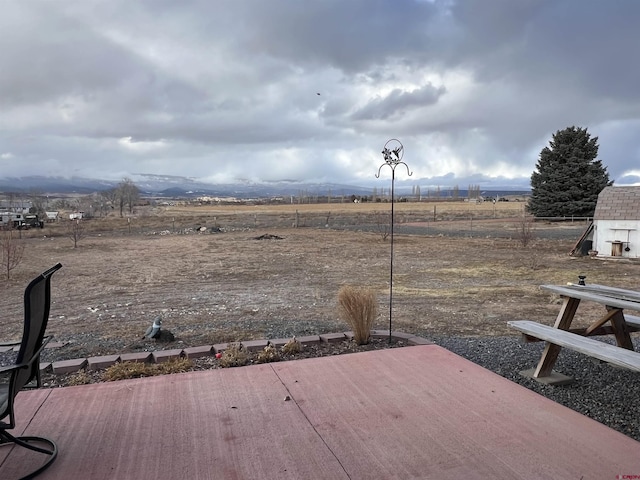 exterior space featuring a deck with mountain view and a rural view