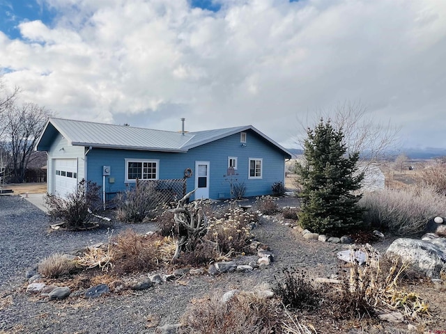 back of property with metal roof and an attached garage