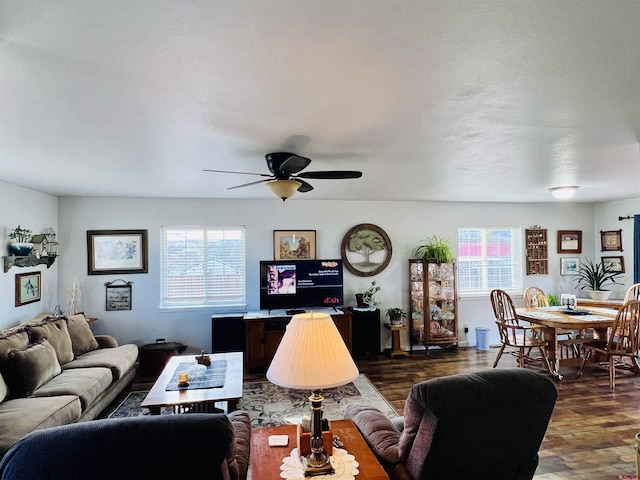 living room featuring ceiling fan, plenty of natural light, and dark wood-style floors