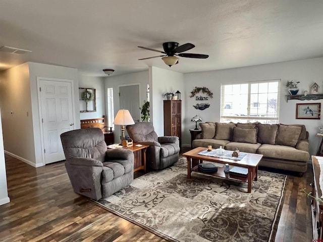 living area with visible vents, dark wood-style flooring, a ceiling fan, and baseboards