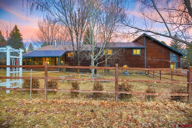 back of property featuring metal roof and fence