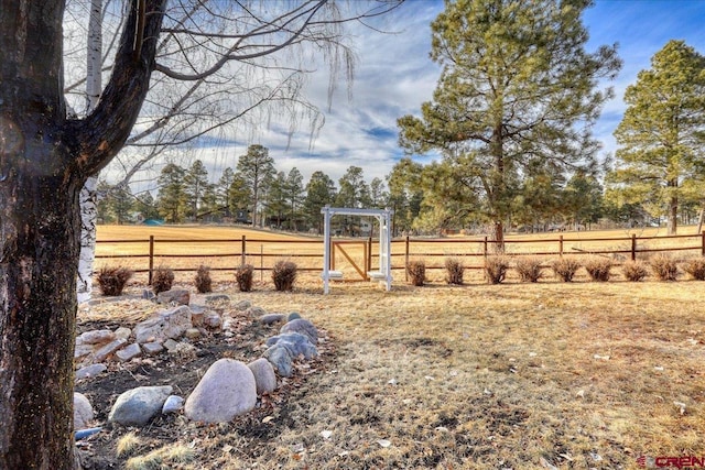 view of yard with a rural view and fence