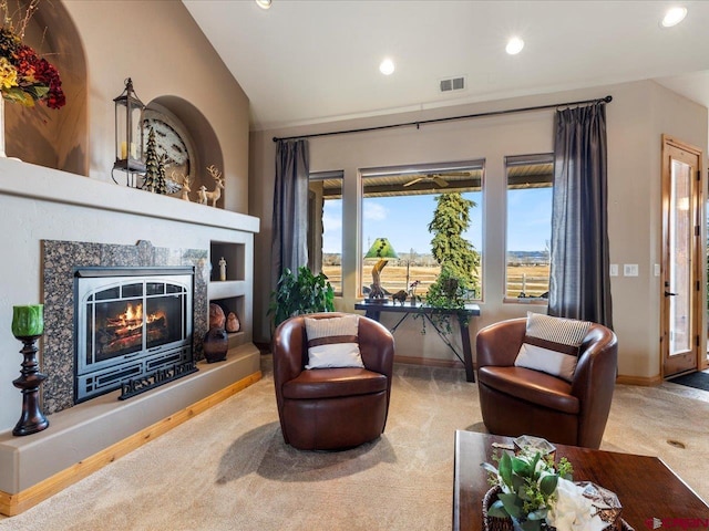 living area with visible vents, a high end fireplace, lofted ceiling, carpet flooring, and recessed lighting