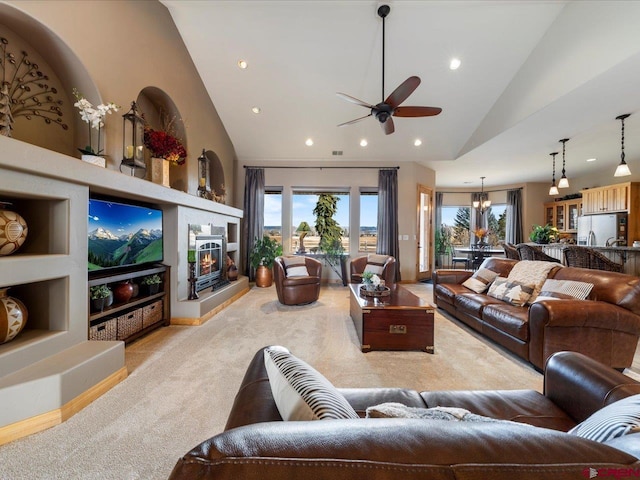 living room with high vaulted ceiling, a glass covered fireplace, light carpet, and recessed lighting