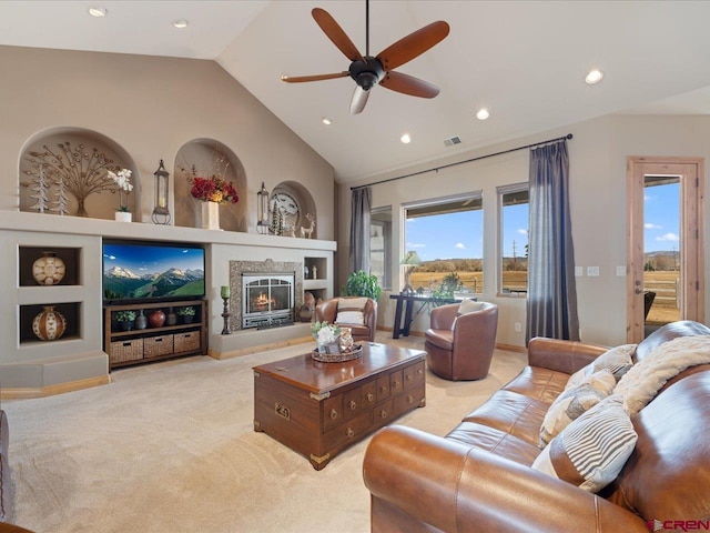 living room with high vaulted ceiling, recessed lighting, light colored carpet, built in features, and a glass covered fireplace