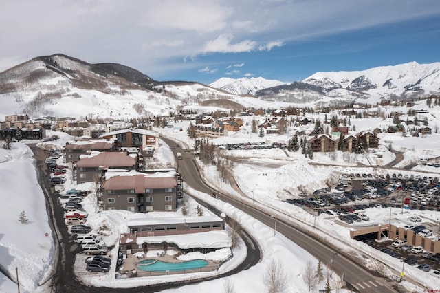 snowy aerial view with a residential view and a mountain view