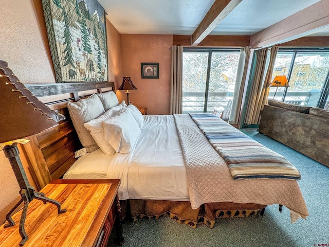 carpeted bedroom featuring access to exterior and beamed ceiling