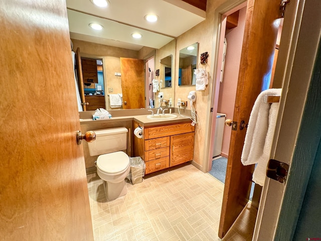 bathroom featuring recessed lighting, vanity, and toilet